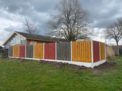 Gekleurde schutting met wit grijze betonpalen