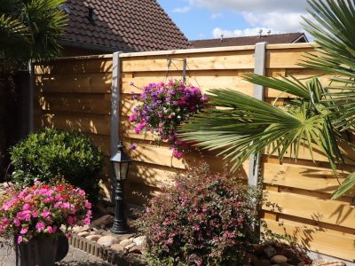 Horizontale grenen schutting met grijze stam betonpalen
